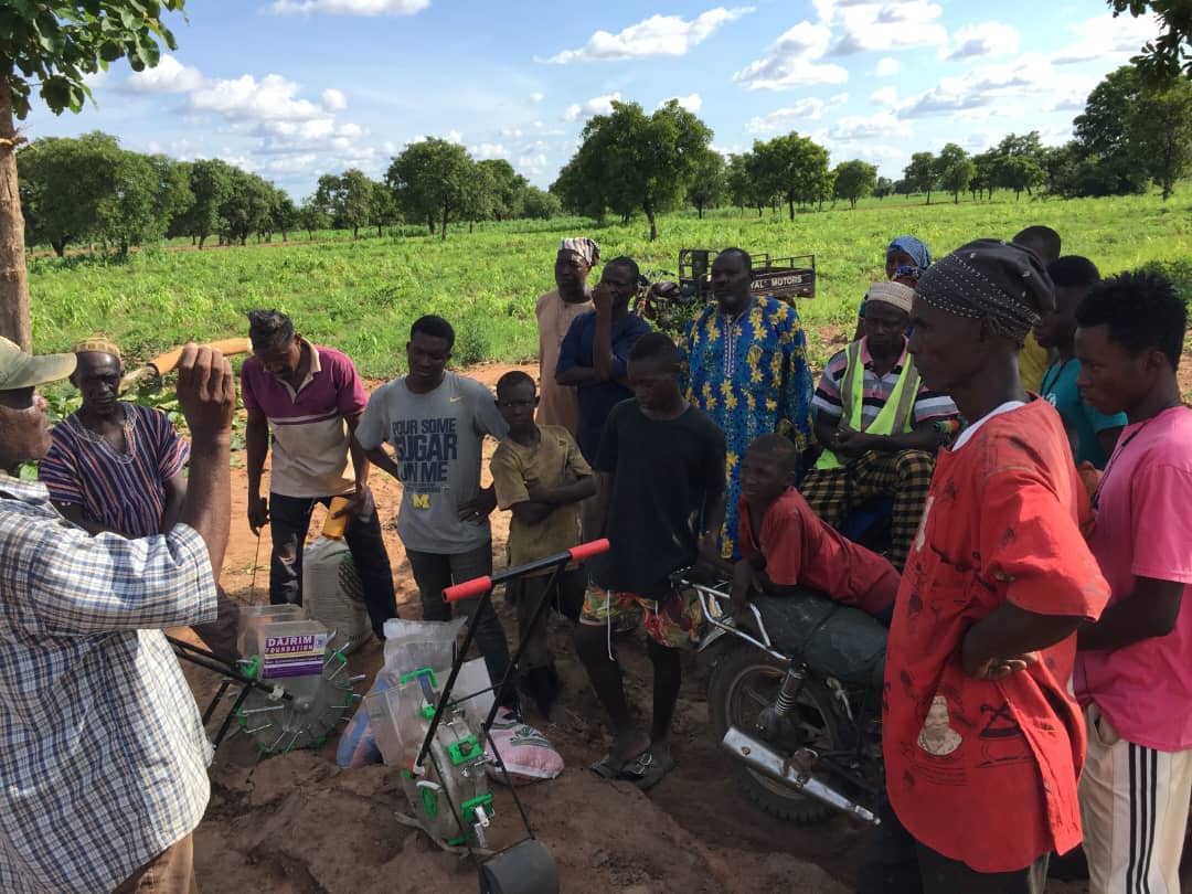 Farmers using a mechanical seeding machine in the field